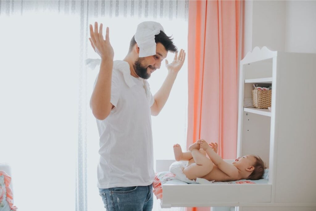 A photo of a dad changing a diaper on his baby.