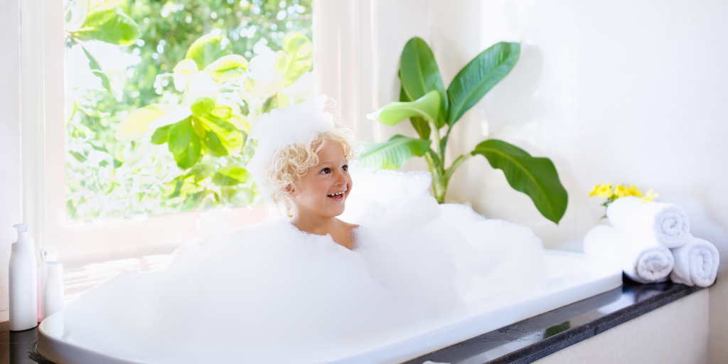 A photo of a kid in a bubble bath with foam created with cocamidopropyl betaine or cocamidopropyl hydroxysultaine surfactants.