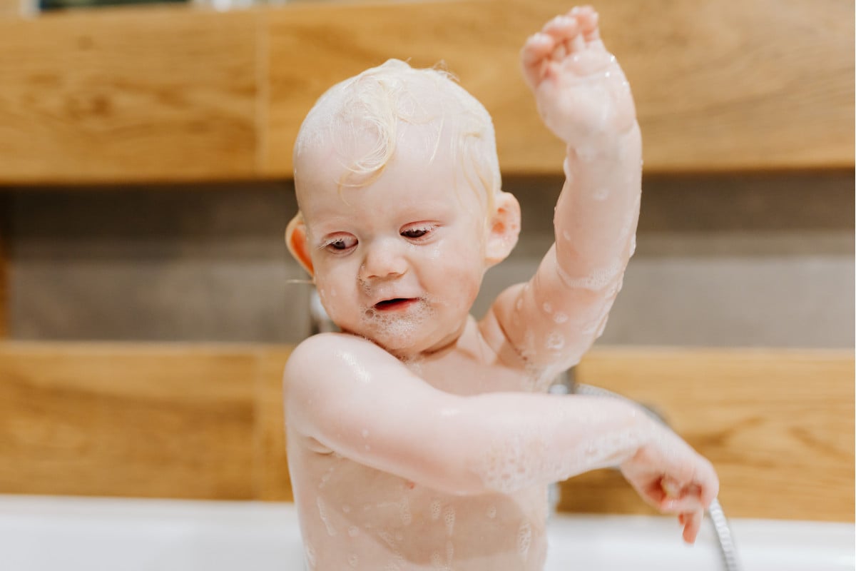 Tear-Free Baby Shampoo I Read Labels For You answer to the question How Do Companies Decide A Shampoo Is Tear-Free. Image of a baby taking a bath using a tear-free shampoo.
