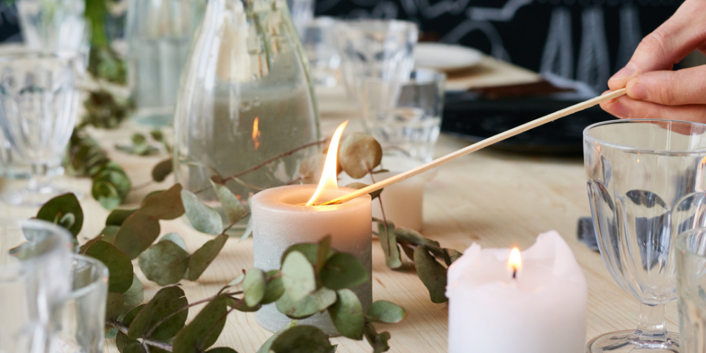 A picture of a non-toxic candle being lit with a stick.