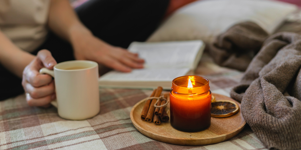 A picture of a woman reading a book with coffee.