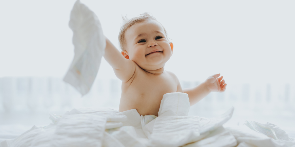 A photo of a baby playing with diapers after being wiped with potentially safe baby wipes.
