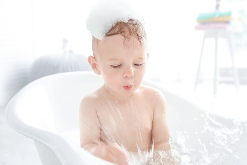 toddler bathing in tub